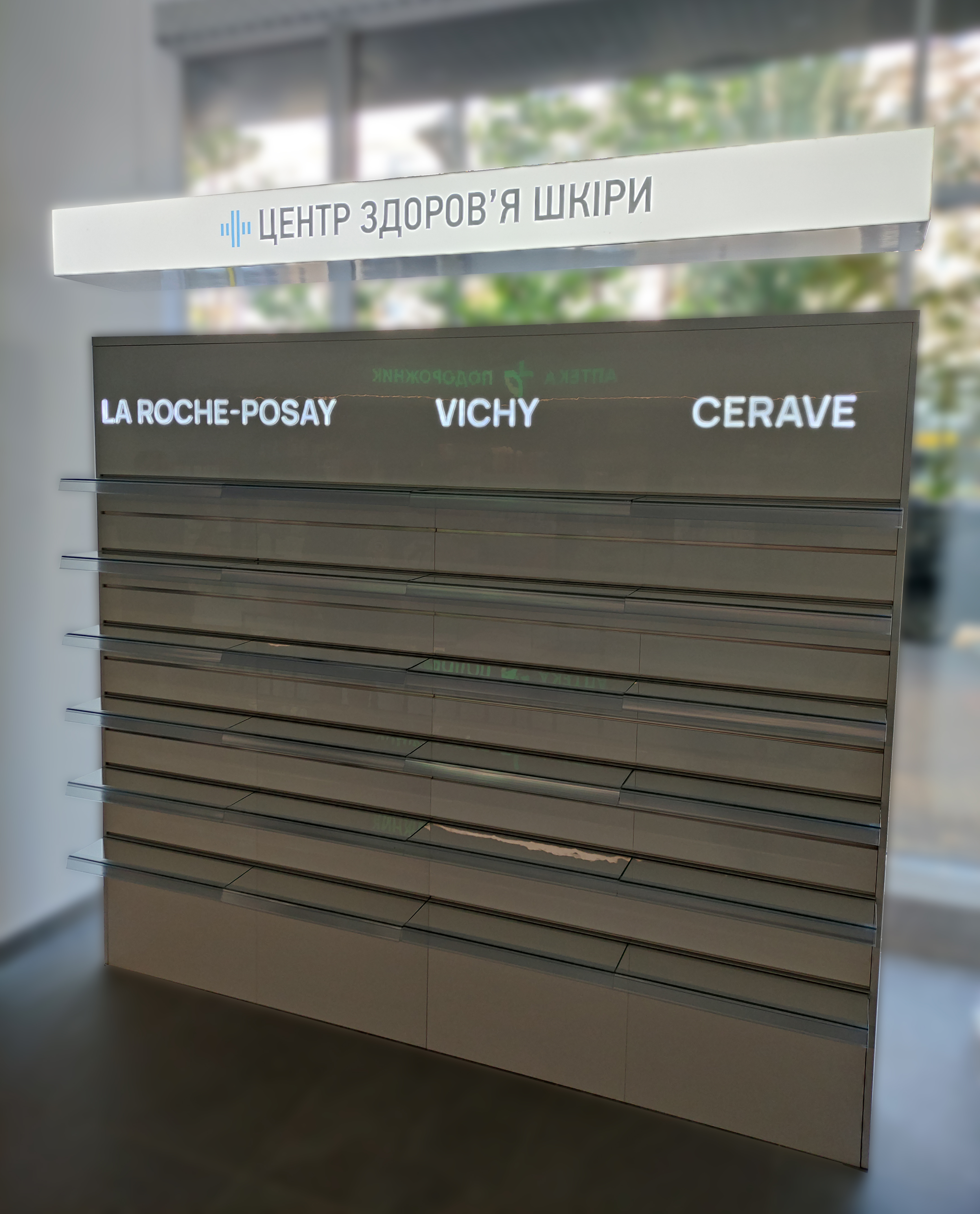 Порожні вітрини в центрі здоров'я шкіри з підсвіченими назвами брендів La Roche-Posay, Vichy, Cerave.
