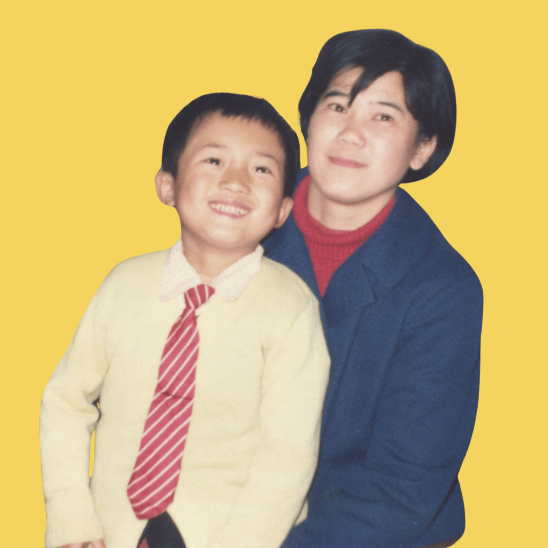Smiling young boy in a striped red tie and cream sweater with an adult woman in a blue coat and red turtleneck against a yellow background.