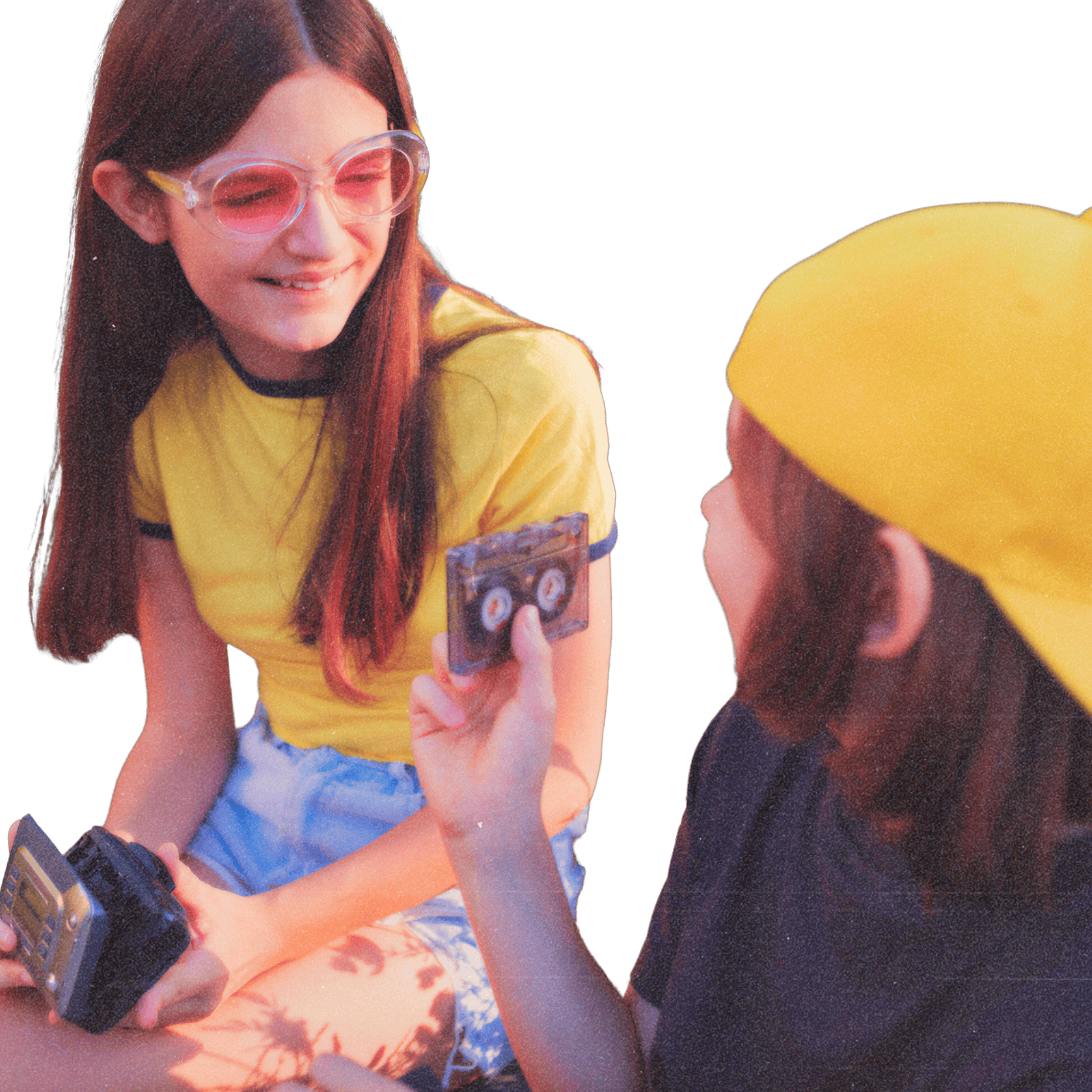 Two young people sitting and sharing a cassette tape, one smiling and holding a cassette player.