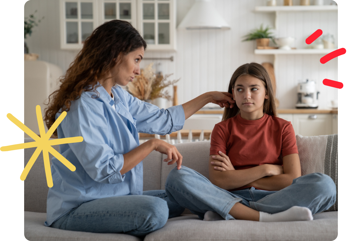 A mother and daughter sitting together on a couch, having a disagreement.