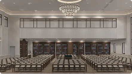 Spacious, elegant library room with rows of chairs facing a central table and a large bookshelf along the back wall under a crystal chandelier.