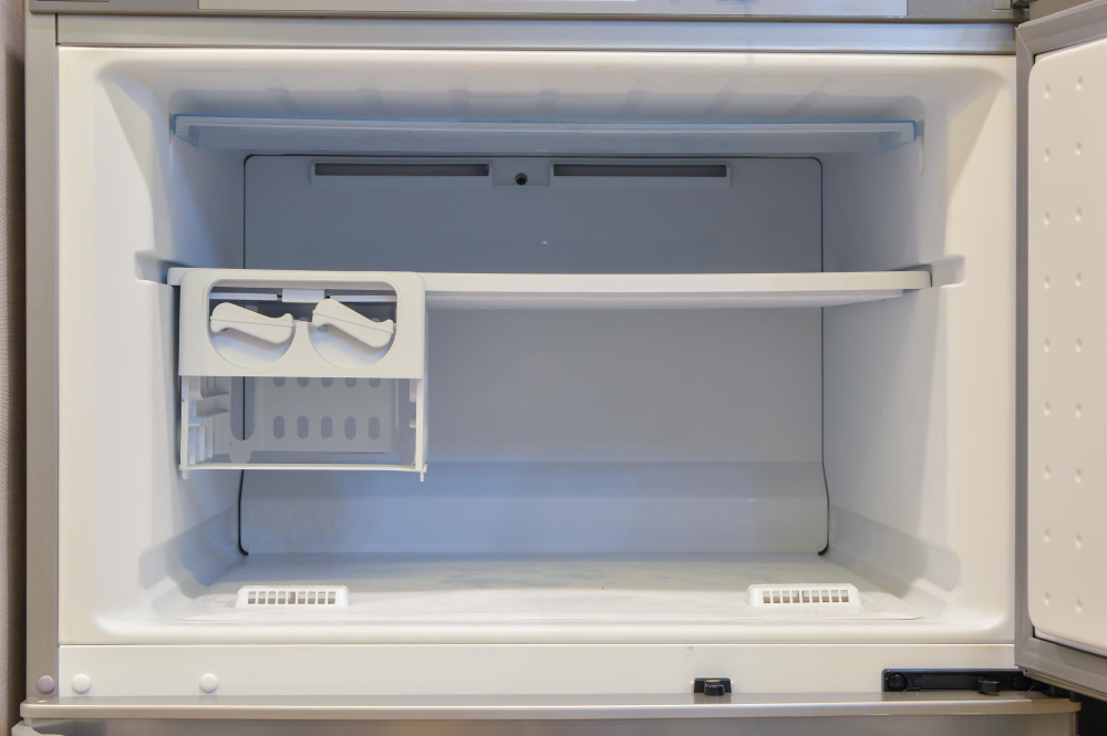 Empty freezer compartment with ice maker inside