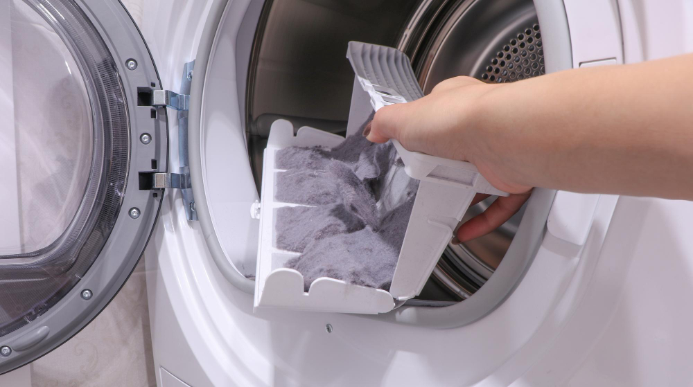 Hand removing lint from dryer filter