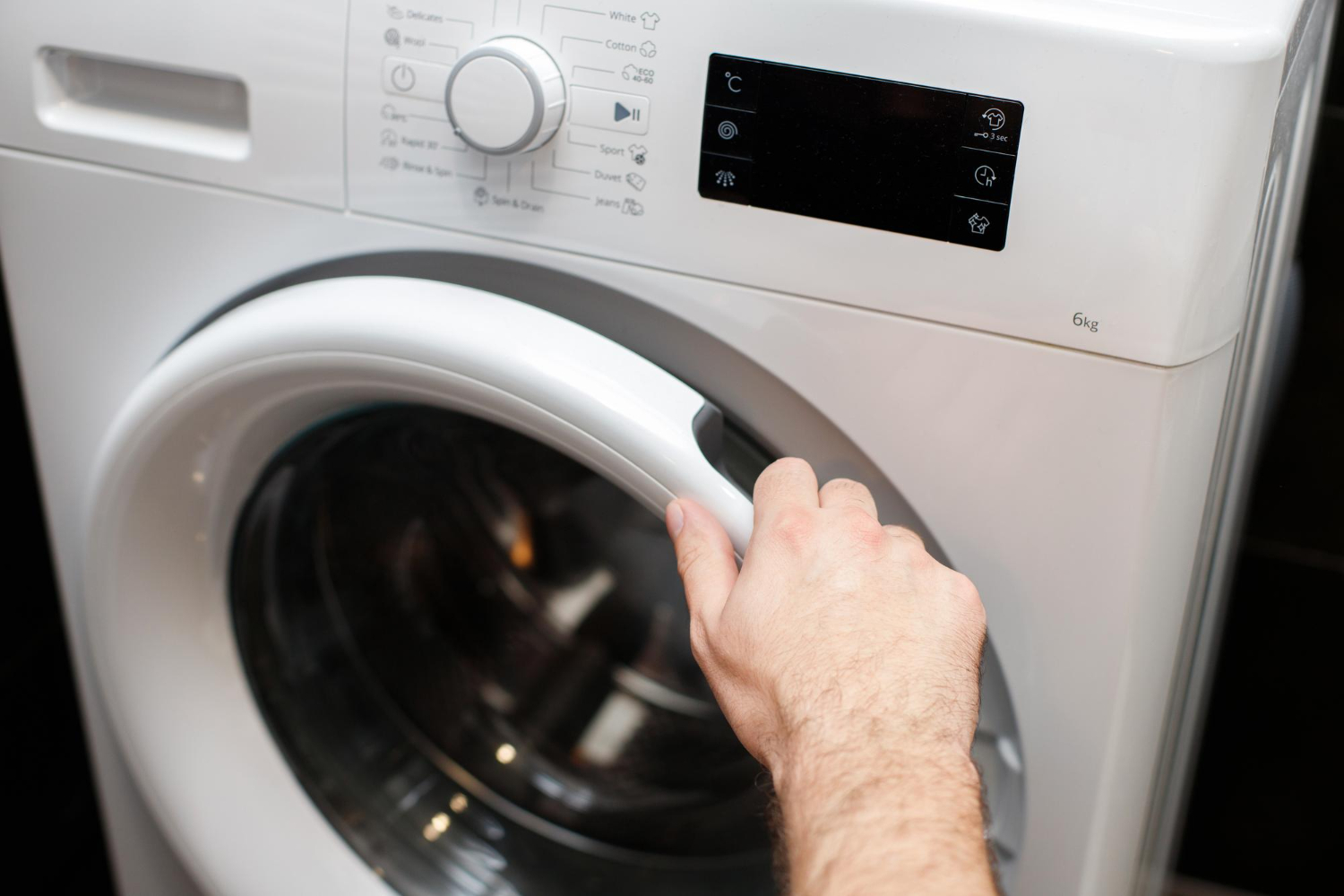 Technician opening front load washing machine door to inspect washer that is not spinning