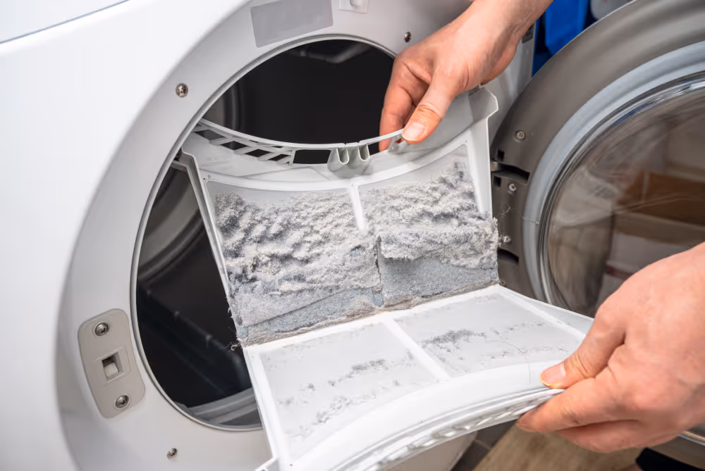 Cleaning clogged dryer lint filter during LG dryer troubleshooting for dryer not heating