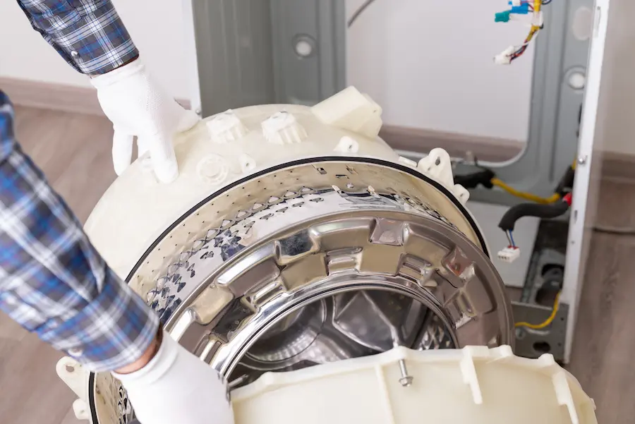 Handyman repairing washing machine drum