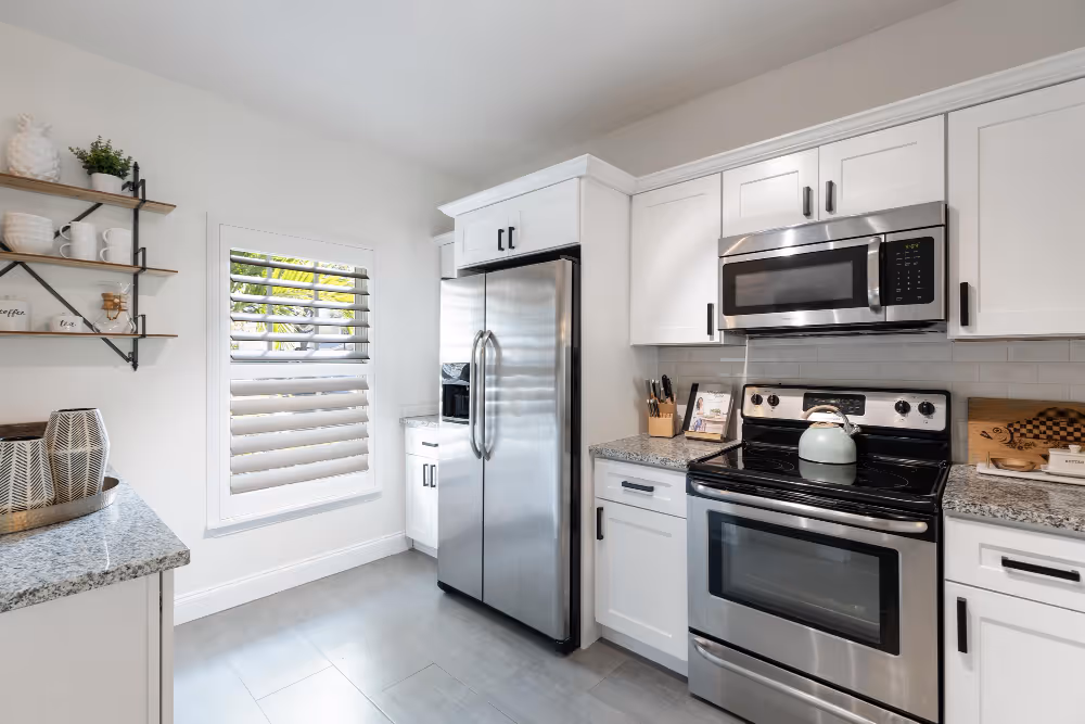 Bright Pomona kitchen with stainless steel appliances and white cabinets