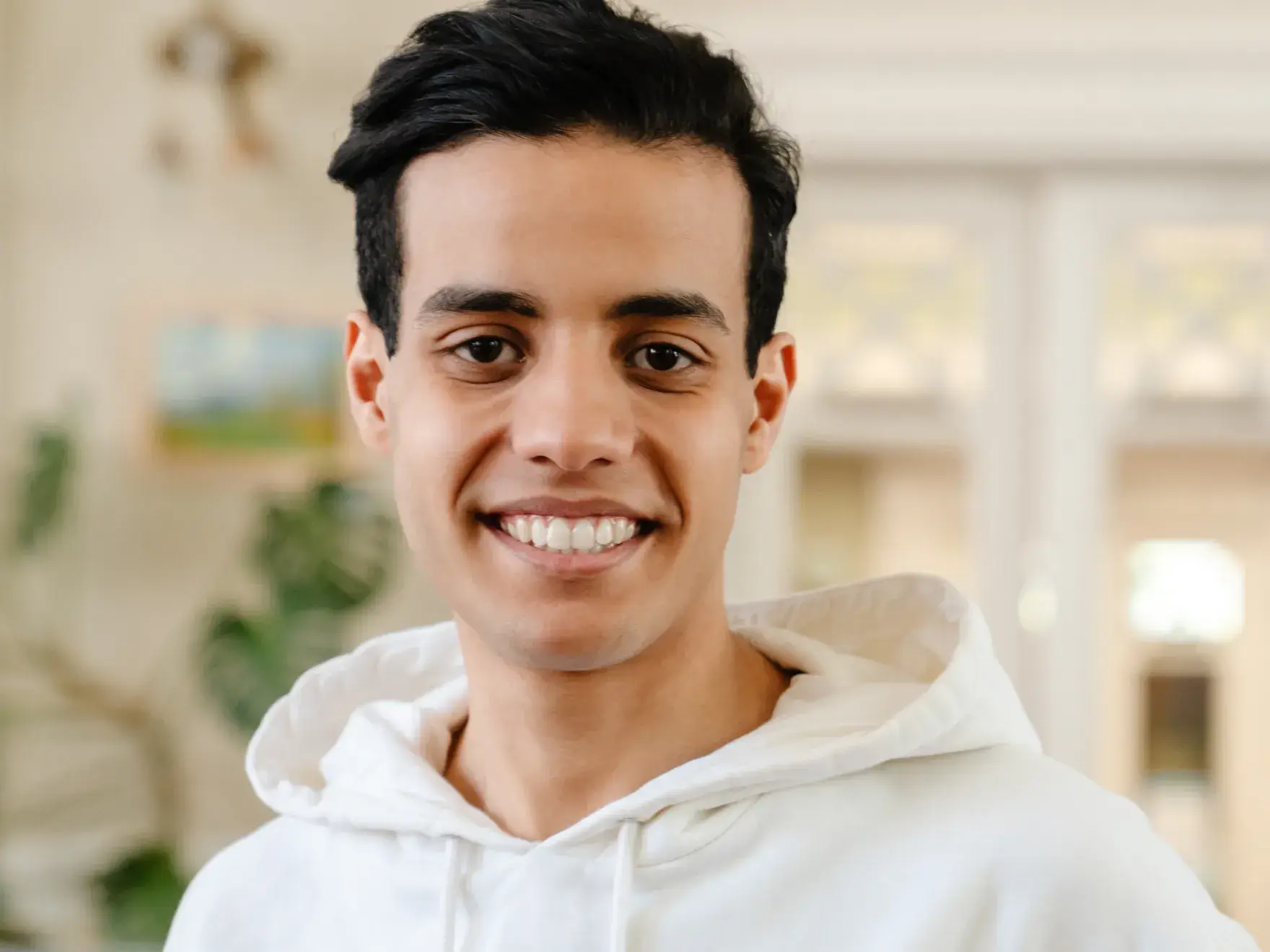 Young men smiling at the camara in white sweter