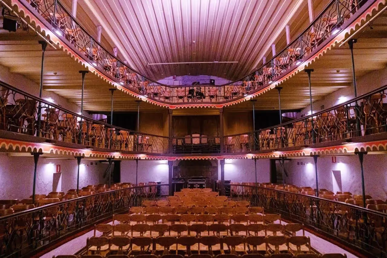 Three story auditorium space with wooden chairs