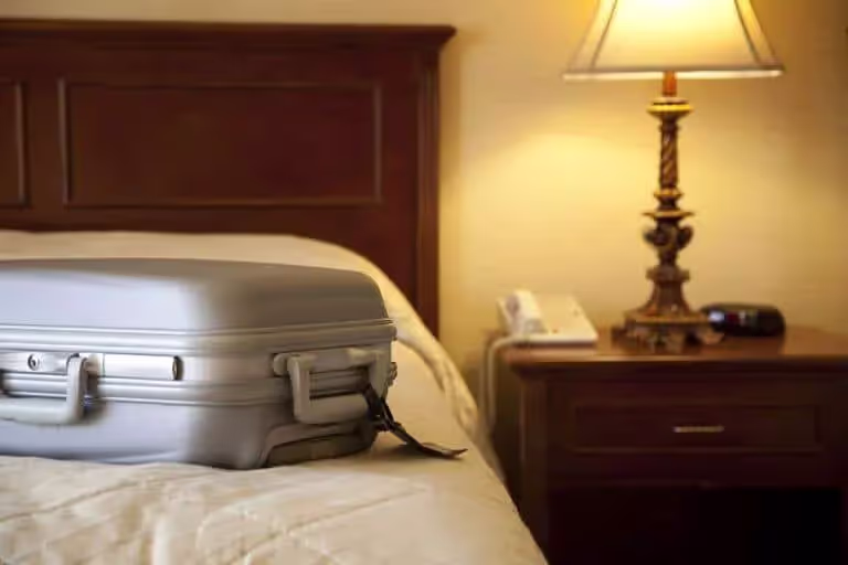 Silver suitcase on hotel bed