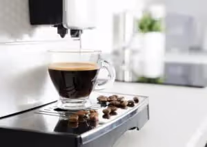 Glass cup full of coffee in coffee maker
