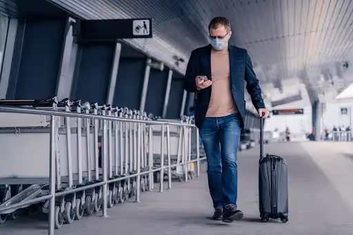 Man walking through airport wearing mask