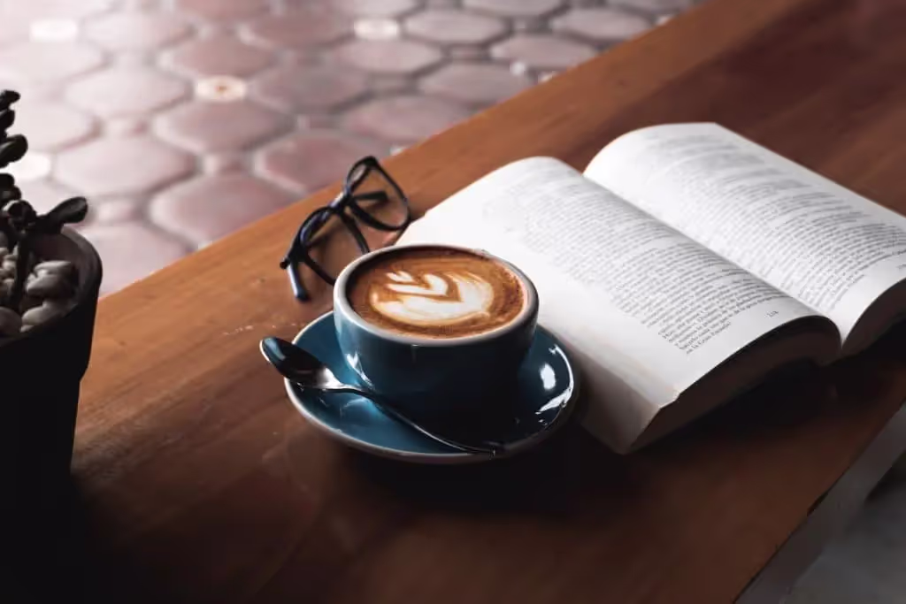 Hospitality book on table next to cup of coffee