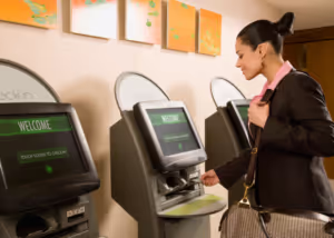 Woman checking into hotel at electronic check-in booth