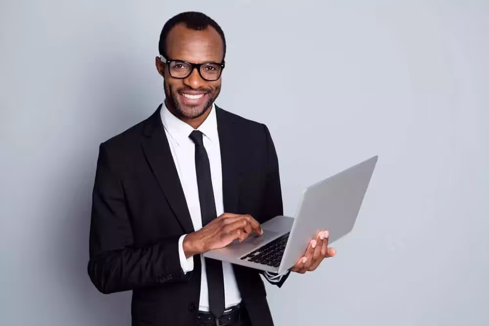 Smiling man holding laptop