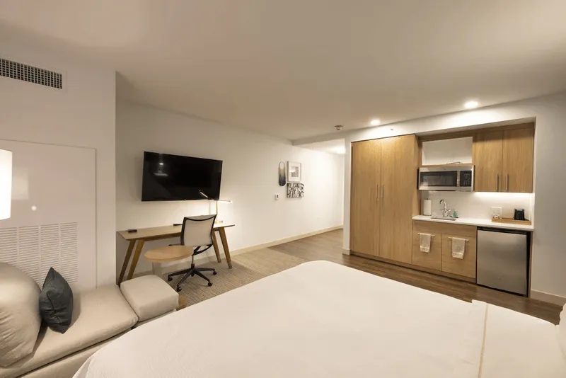 A room with a bed and a deskDescription automatically generated