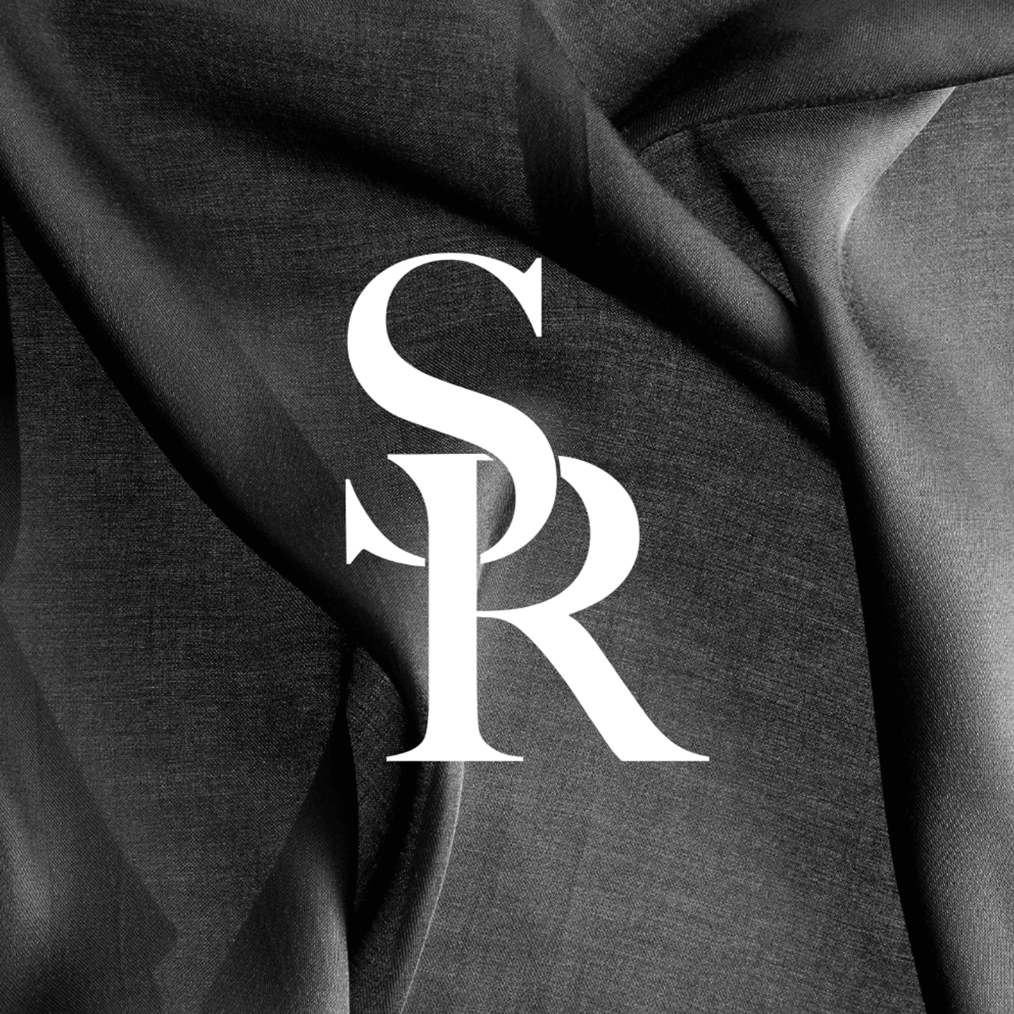 Stylized white letters S and R overlapping on a dark textured fabric background.