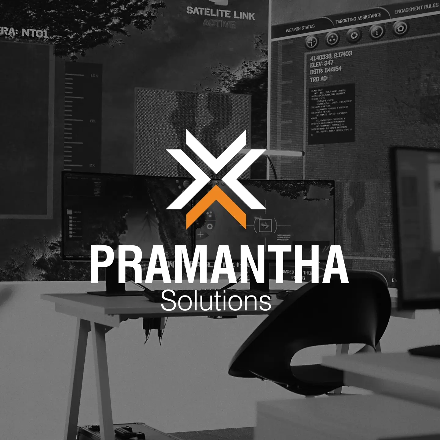 Office workspace with a desk, computer monitors displaying technical data, and the Pramantha Solutions logo overlay.