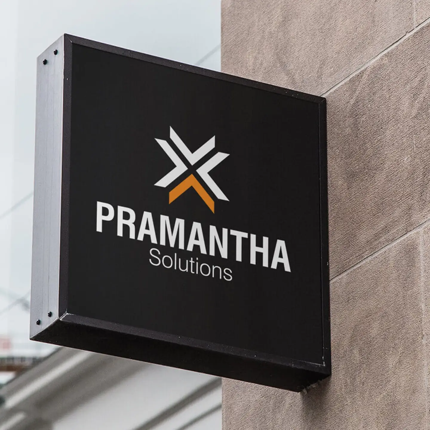 Black rectangular outdoor sign with white and orange geometric logo above the text 'PRAMANTHA Solutions' mounted on a brown wall.