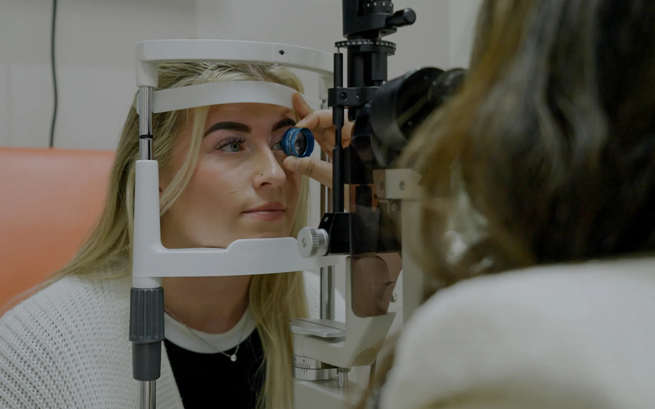 Optometrist performing comprehensive eye examination with slit lamp for patient eye health evaluation