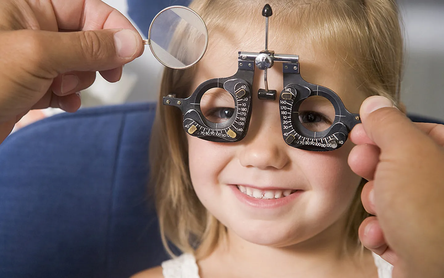 Child undergoing eye examination with trial frame for accurate prescription assessment