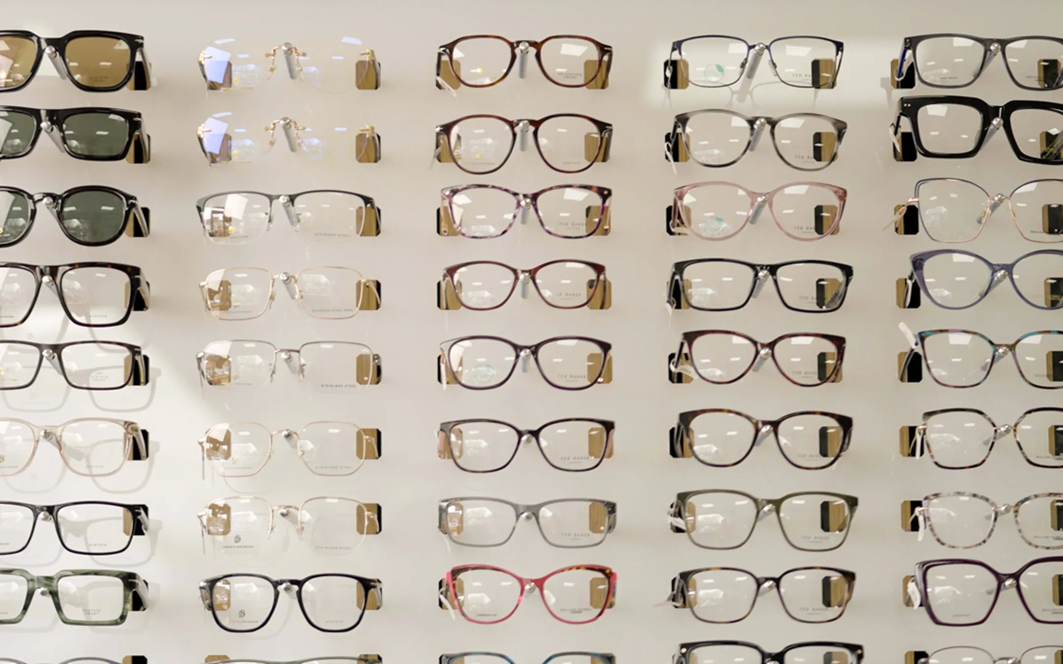 Extensive prescription eyeglasses display wall featuring designer frames at independent opticians