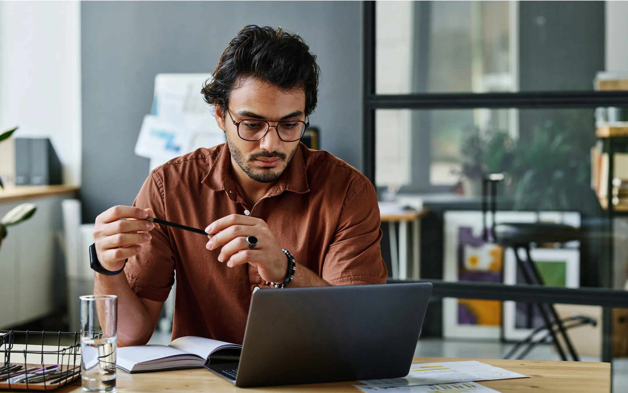 Professional wearing prescription eyeglasses reviewing documents and privacy information at desk