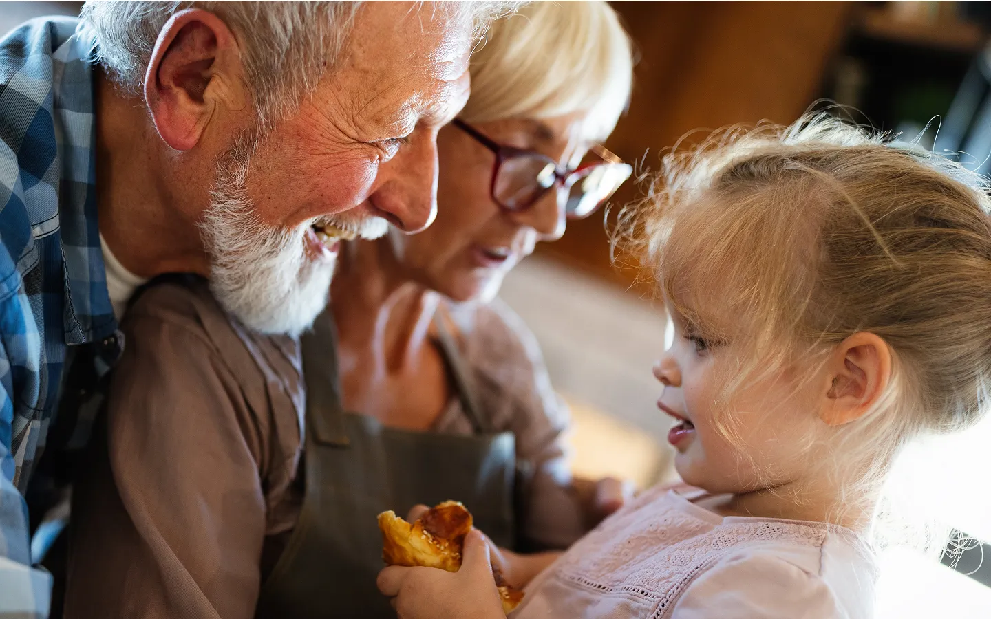 Grandparents with hearing aids interacting with young grandchild showing benefits of hearing care