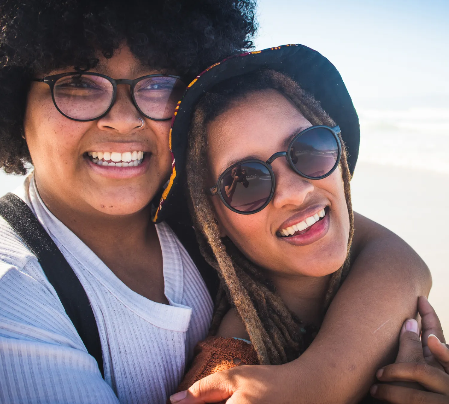 Happy customers wearing designer sunglasses and prescription eyeglasses from independent optician