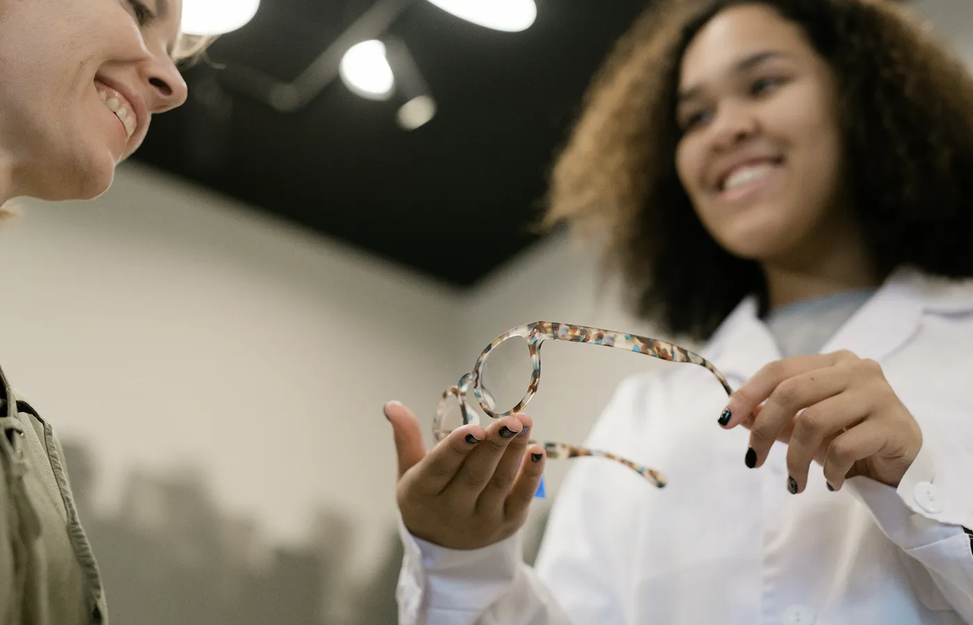 Optometrist helping new patient select designer prescription eyeglass frames