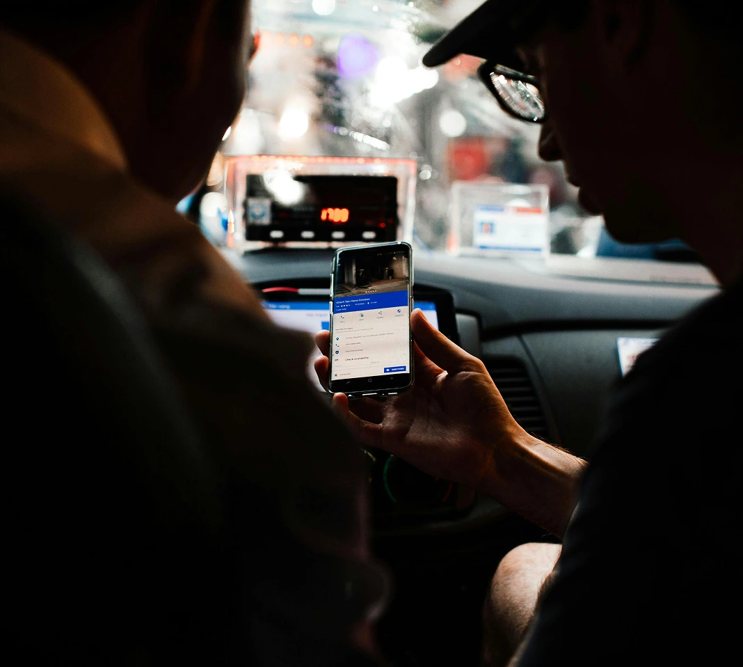 Client qui traduit avec son téléphone à son chauffeur taxi