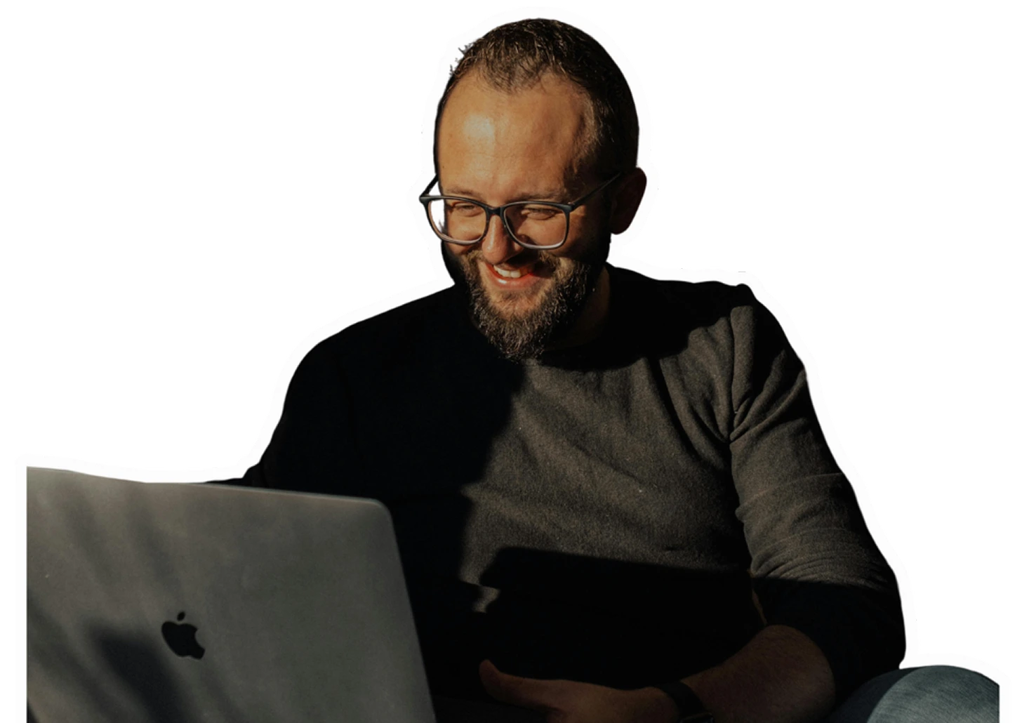 Un homme souriant devant son ordinateur