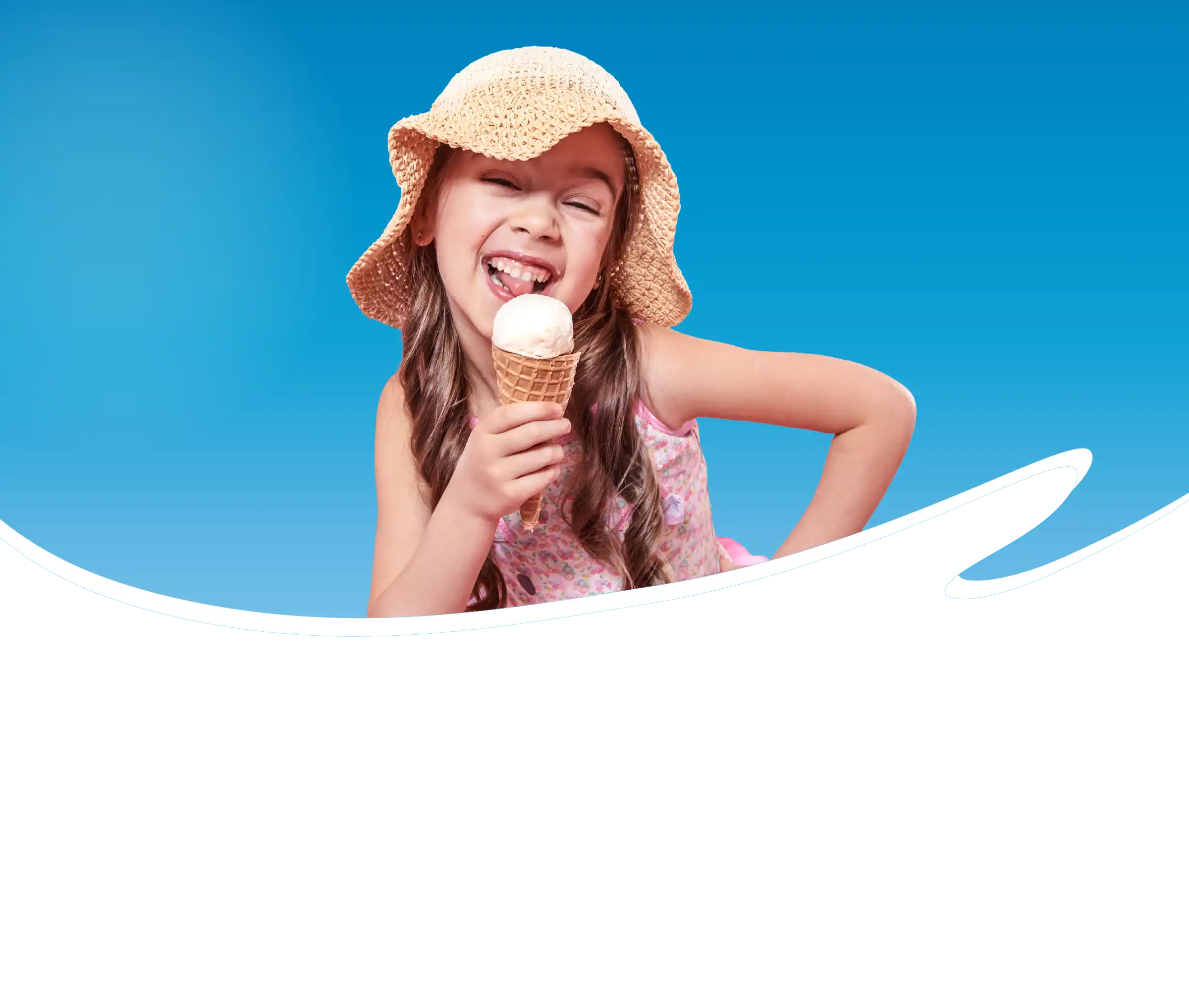 Lachend meisje met strohoed geniet van een ijsje in hoorntje tegen een blauwe achtergrond.