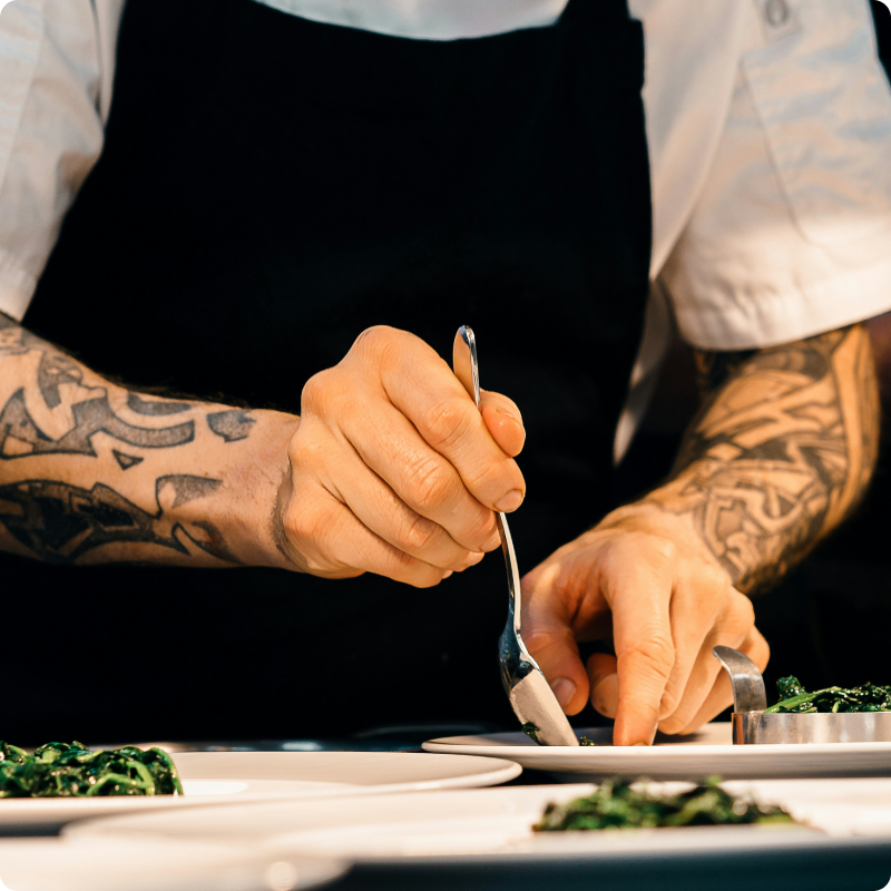 Kokk anretter mat på tallerken.