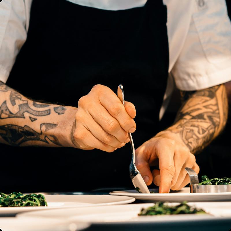 Kokk anretter mat på tallerken.