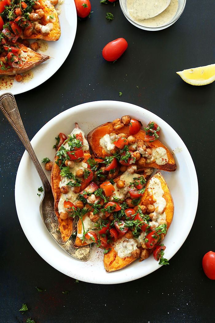 Mediterranean sweet potatoes topped with chickpeas, tomatoes, feta cheese, and fresh herbs.