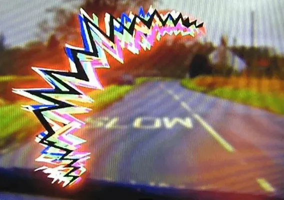 Blurred road scene with colorful zigzag graphic overlay creating a distortion effect.