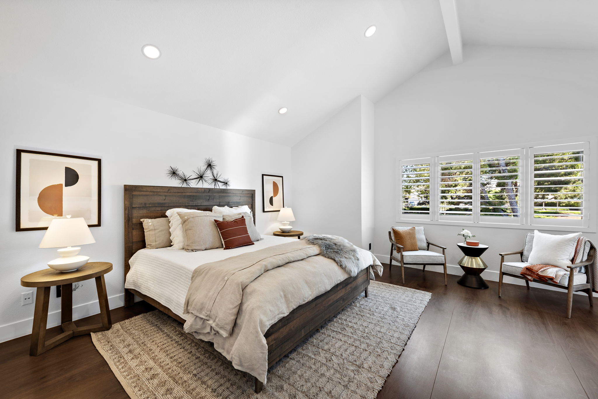 Bayside Residence bedroom with warm flooring, soft light, and calm neutral styling.