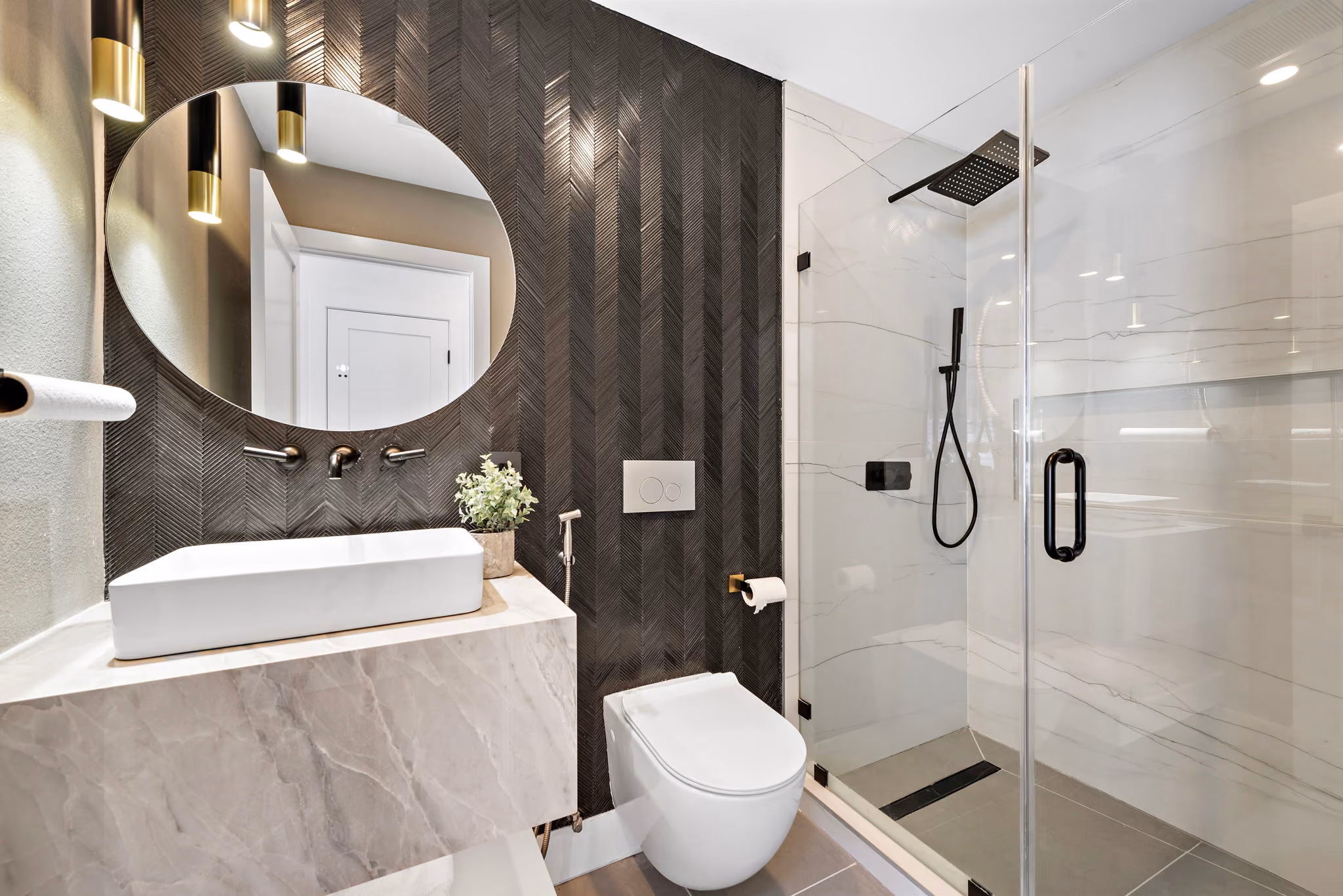 Bayside Residence bathroom with glass shower, bold textured tile, and streamlined modern fixtures.
