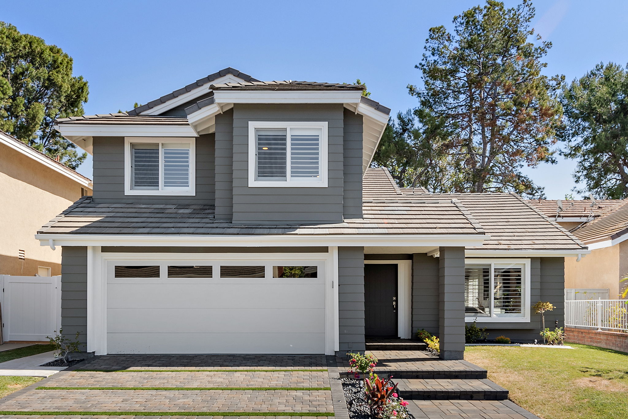 Bayside Residence exterior in Irvine with bright modern architecture, warm details, and landscaped outdoor space.