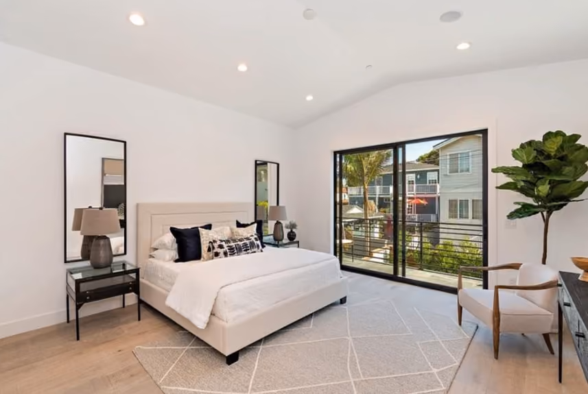 Maple Residence bedroom with wide plank oak floors, large windows, and calm minimalist styling.