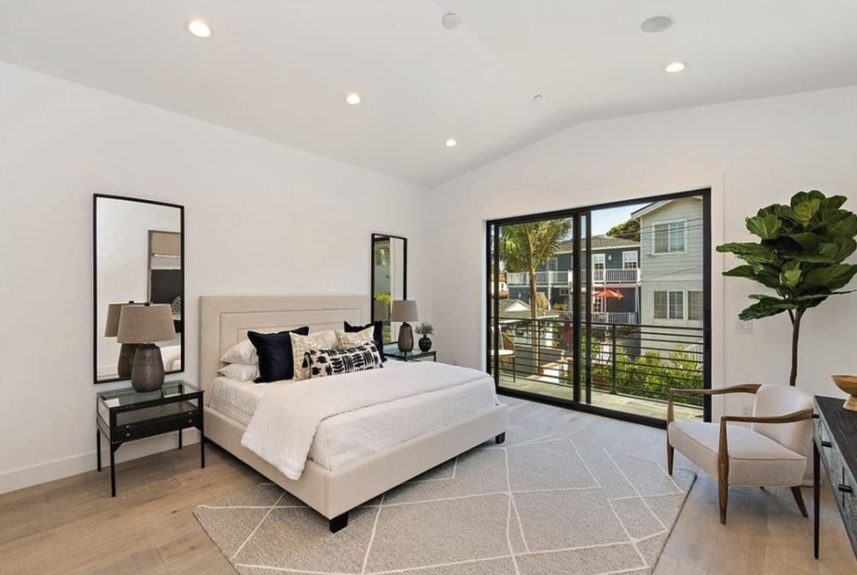 Maple Residence bedroom with wide plank oak floors, large windows, and calm minimalist styling.