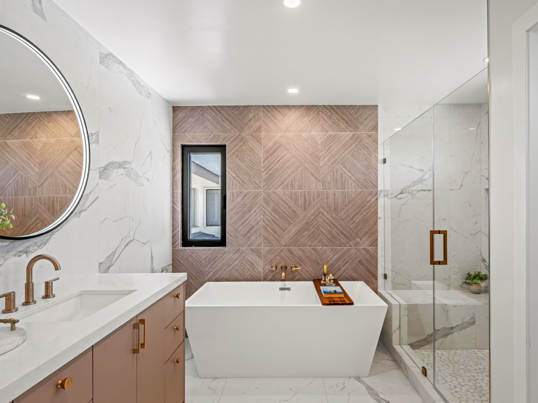 Whitewater Residence bathroom with freestanding tub, glass shower, large-format stone, and warm metal fixtures.