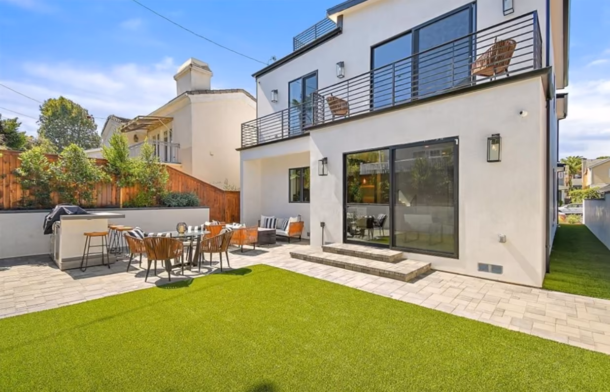 Maple Residence outdoor terrace connected to bright modern interiors through wide glass doors.
