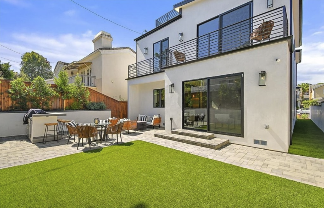 Maple Residence outdoor terrace connected to bright modern interiors through wide glass doors.