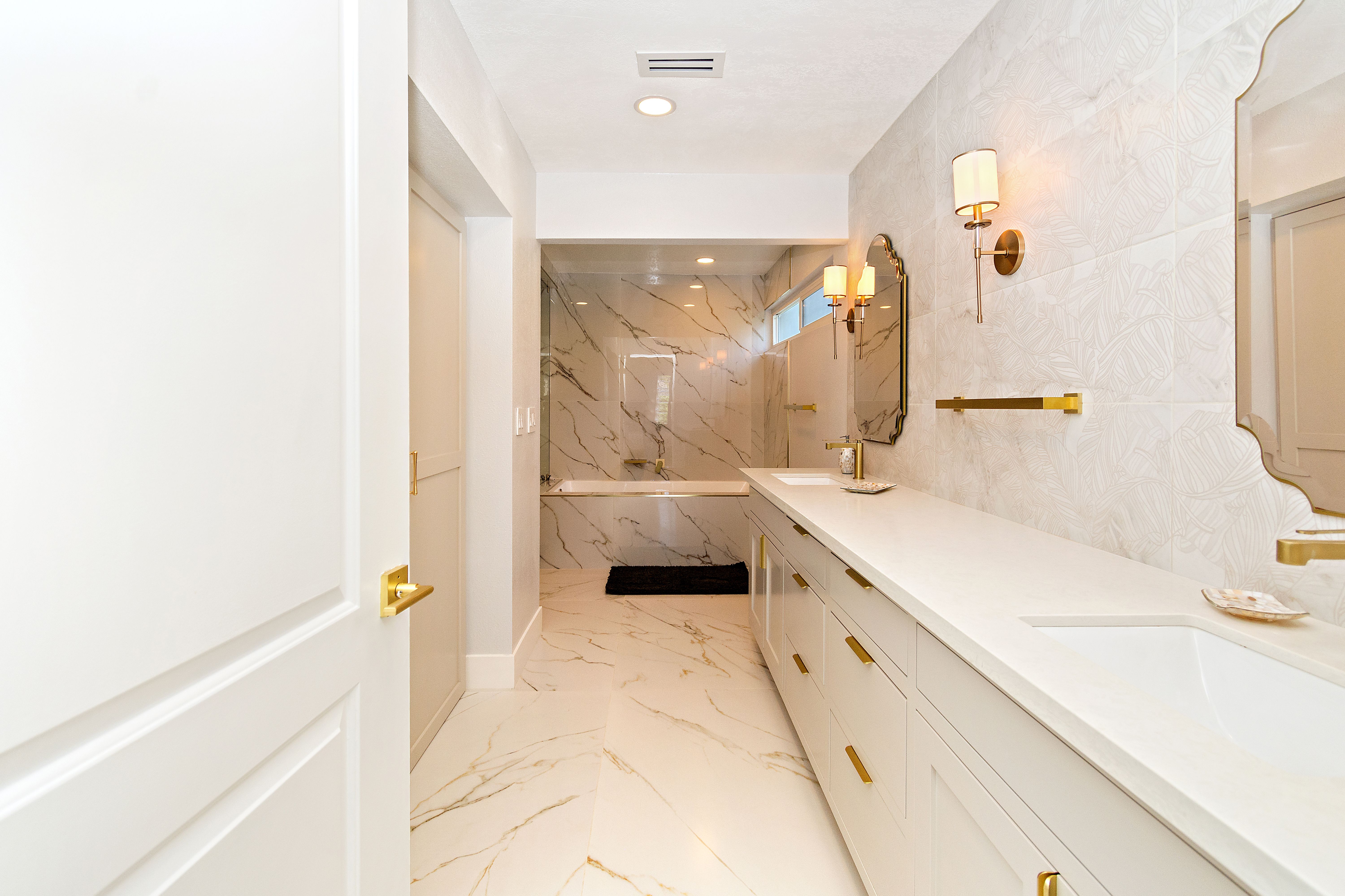 Rainstar Residence bathroom with double vanity, marble surfaces, brass fixtures, and bright spa-like finishes.
