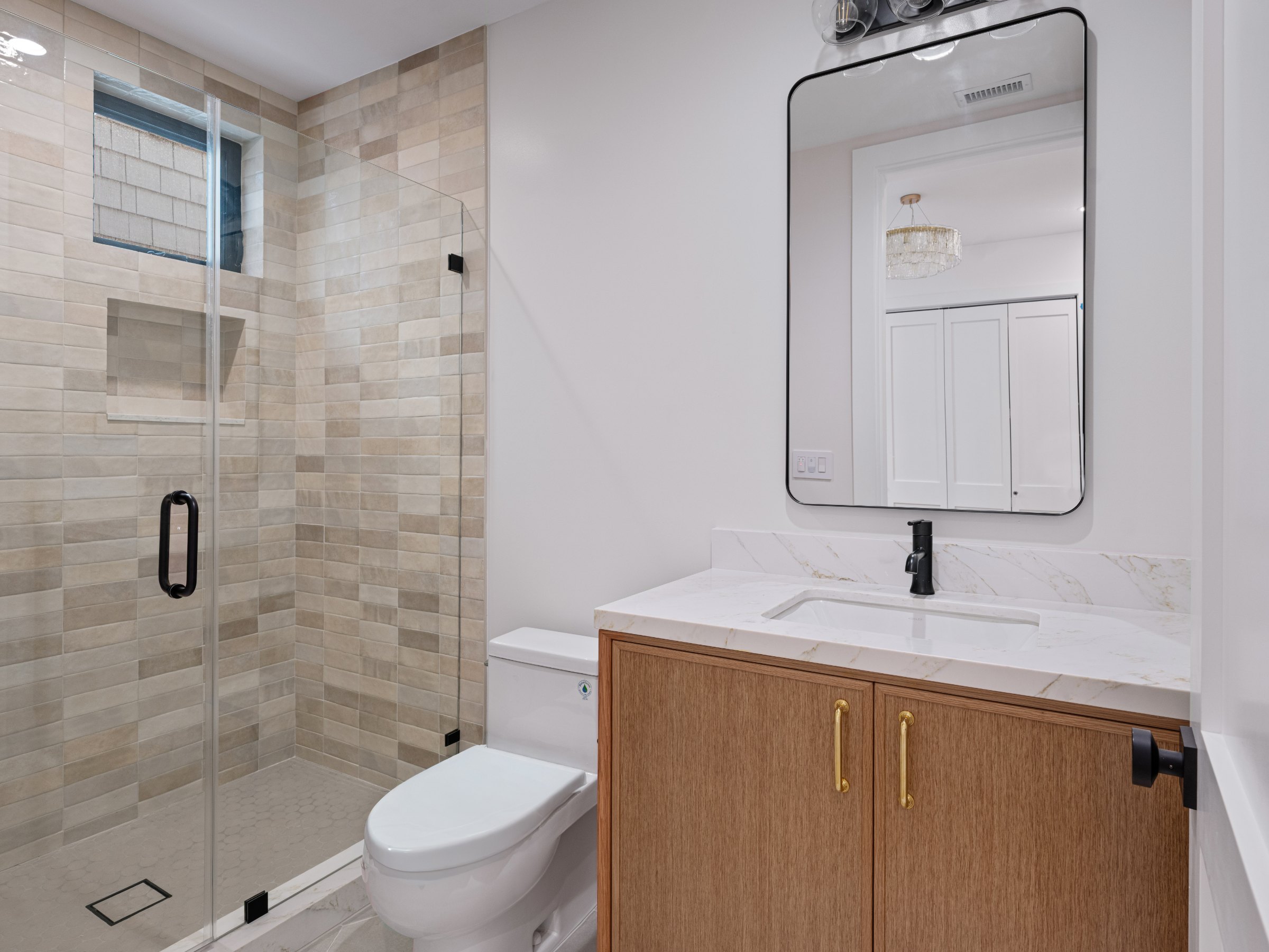 Pine Residence bathroom with glass shower and wood vanity