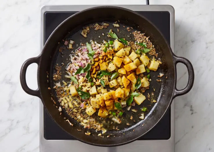 The curry leaves, onion, green chillies, ginger, potato, and turmeric powder.