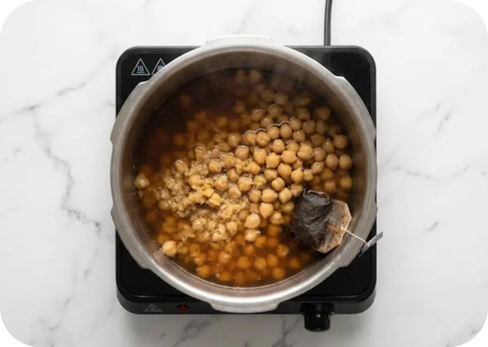 Pressure cook the soaked chickpeas, salt and the tea bag