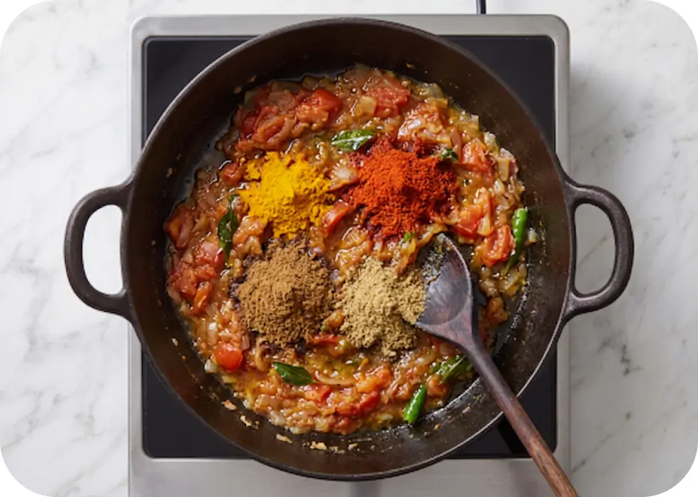 chopped tomato, turmeric powder, red chilli powder, cumin powder, dry mango powder, garam masala, ground coriander seed powder, and anardana powder. 